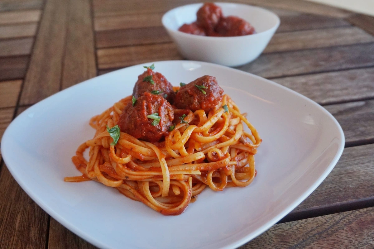 Hand-rolled basil meatballs over spaghetti pomodoro with Parmesan