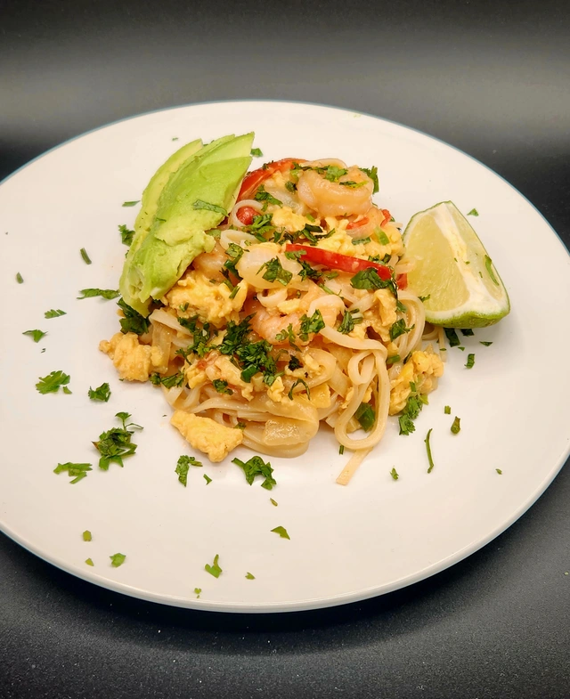 Shrimp pad thai with egg, avocado, cilantro, and lime