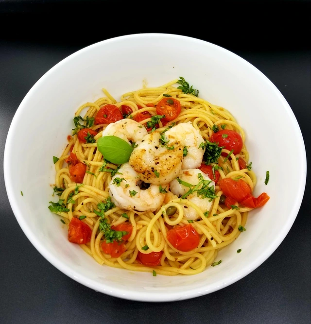 Shrimp spaghetti with blistered cherry tomatoes, capers, and fresh basil