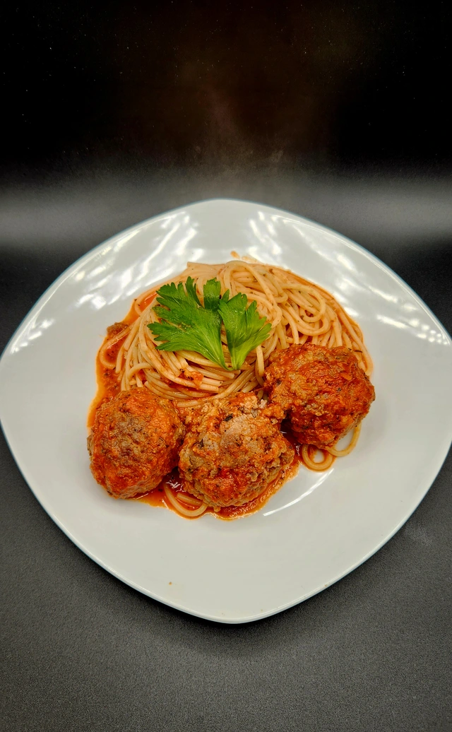 Spaghetti and meatballs in marinara sauce with fresh parsley